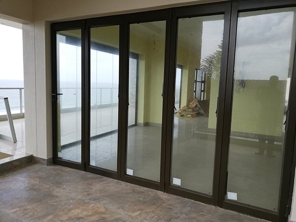 Aluminium stacking doors along a covered balcony with sea views