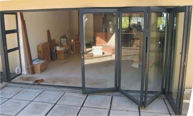 Aluminium folding doors concertinaed open onto a paved patio