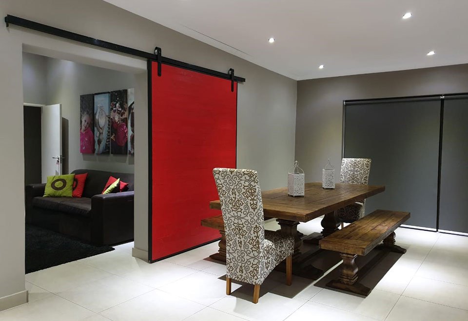 Bright red sliding barn door in a contemporary dining space