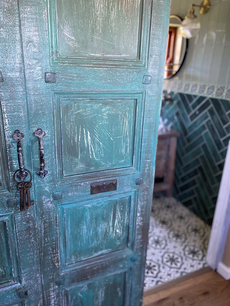 Ornate antique teal barn door with decorative ironmongery