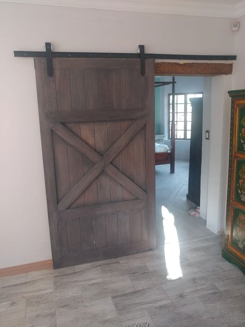 Classic dark stained X-brace barn door on a passage opening