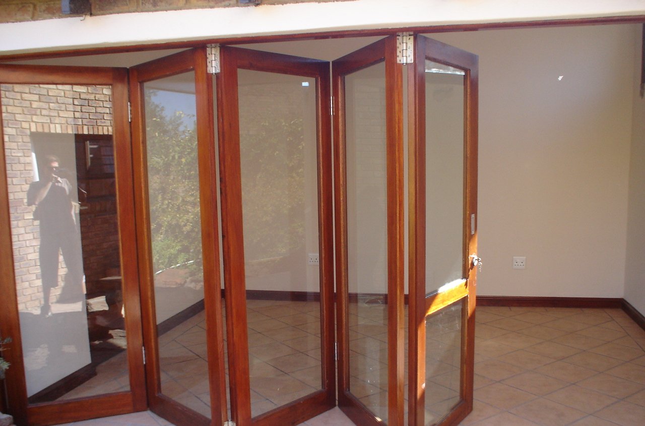 Rich red-brown folding doors concertinaed open in a tiled interior