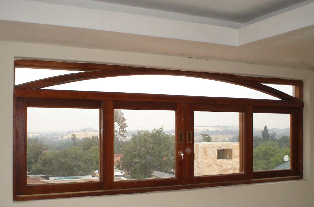Timber folding window unit with a curved arch top over a valley