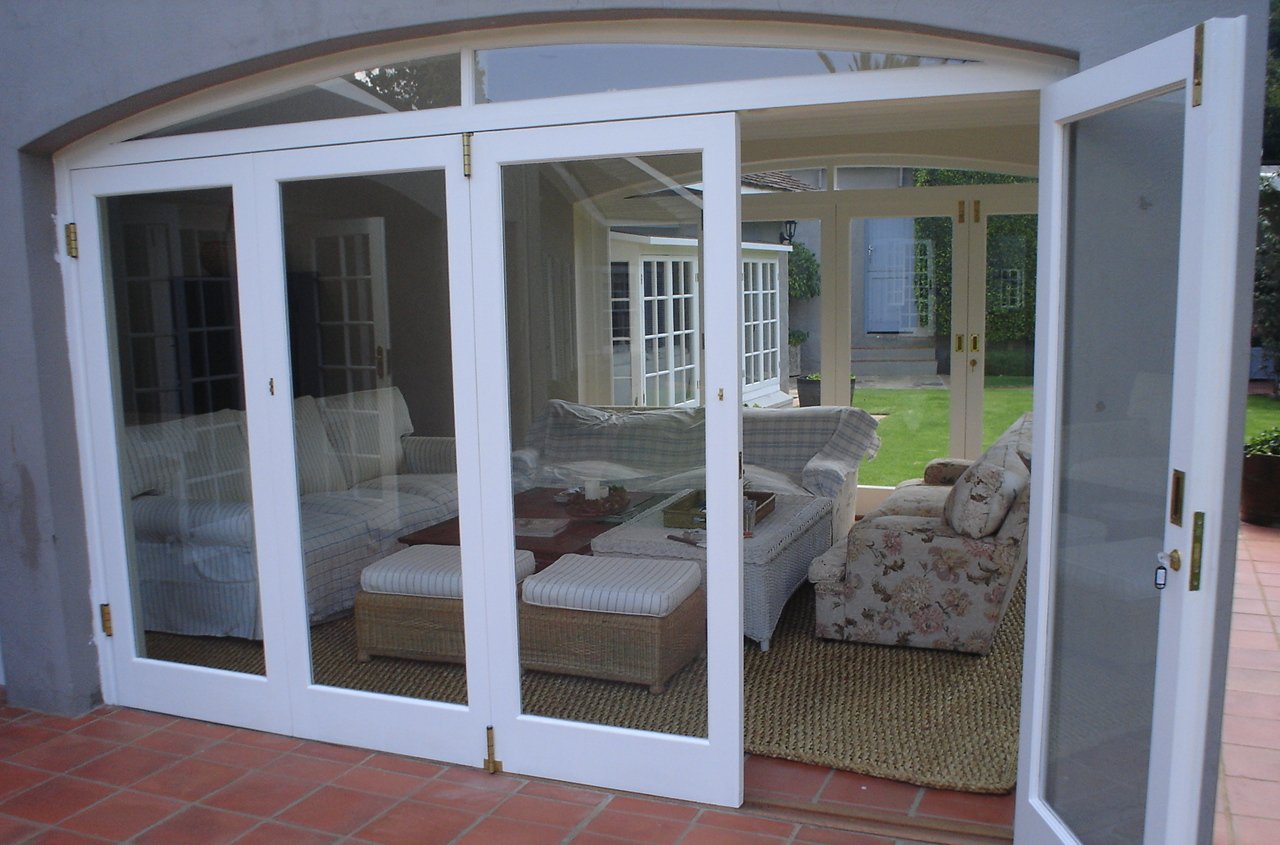 White folding doors enclosing a garden-facing living room