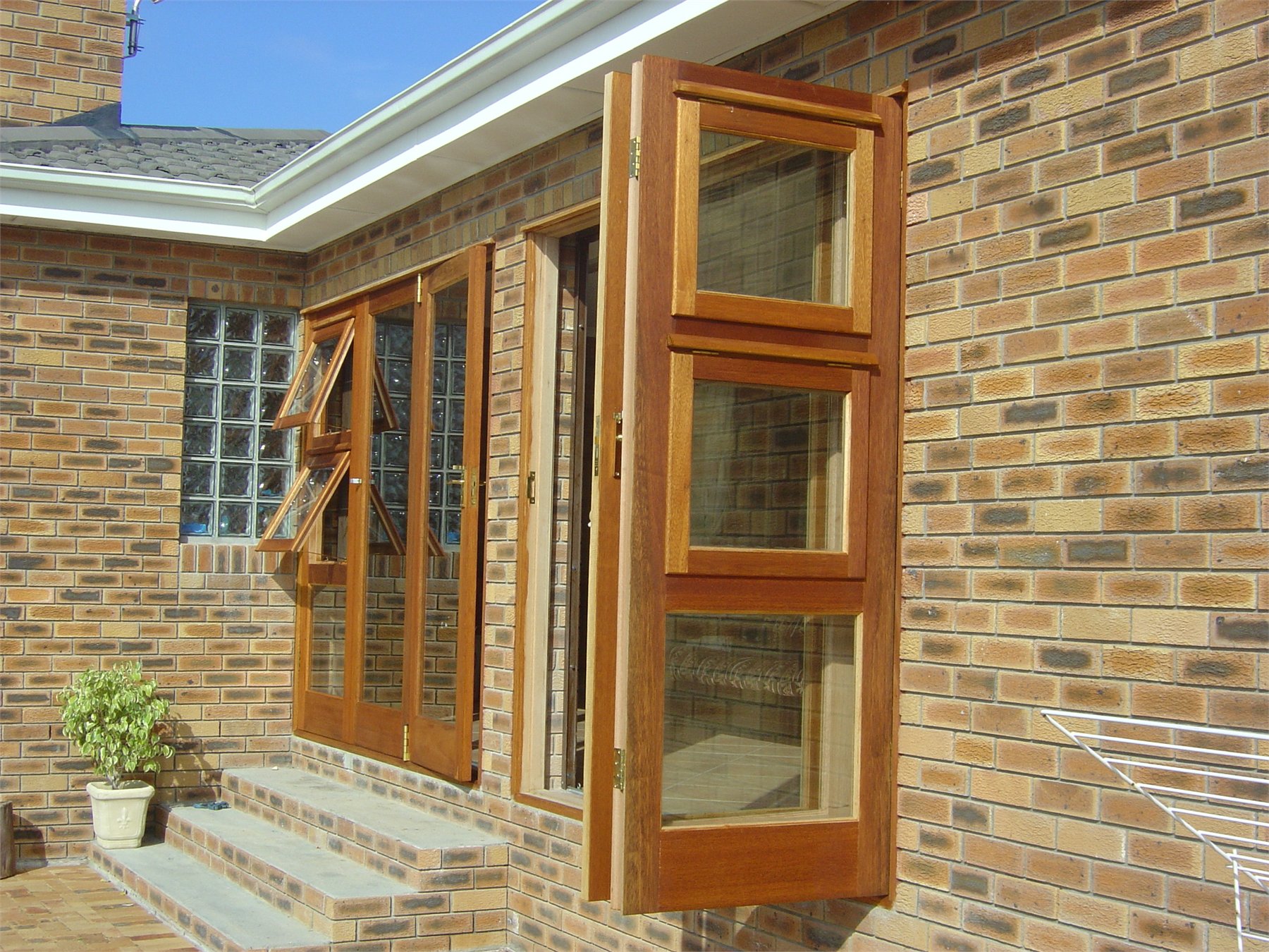 Face-brick home with timber folding windows propped open