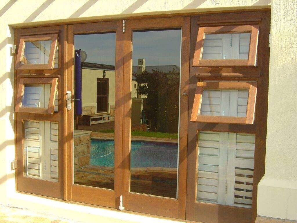 Hardwood folding window doors beside a swimming pool