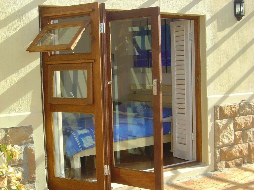 Timber folding window doors opened outward from a stone wall