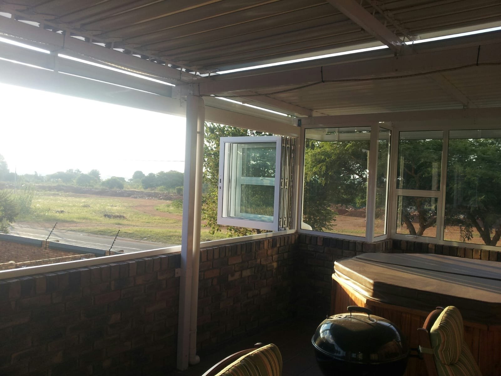 Covered veranda glazed with folding window doors and open country views