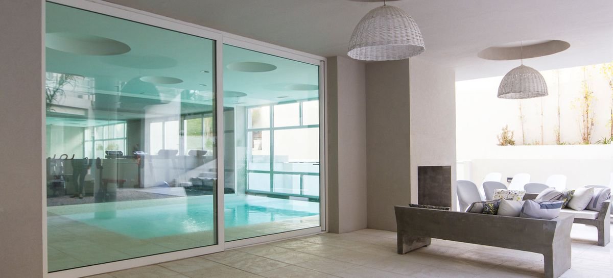 Indoor pool room glazed in white uPVC sliding panels